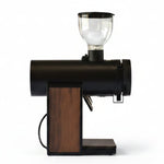 A modern electric coffee grinder with a matte black body, a clear glass hopper on top, and a vertical wood-grain panel on the front, isolated on a white background.