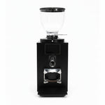 A black coffee grinder with a clear glass bean hopper on top, shown against a plain white background.