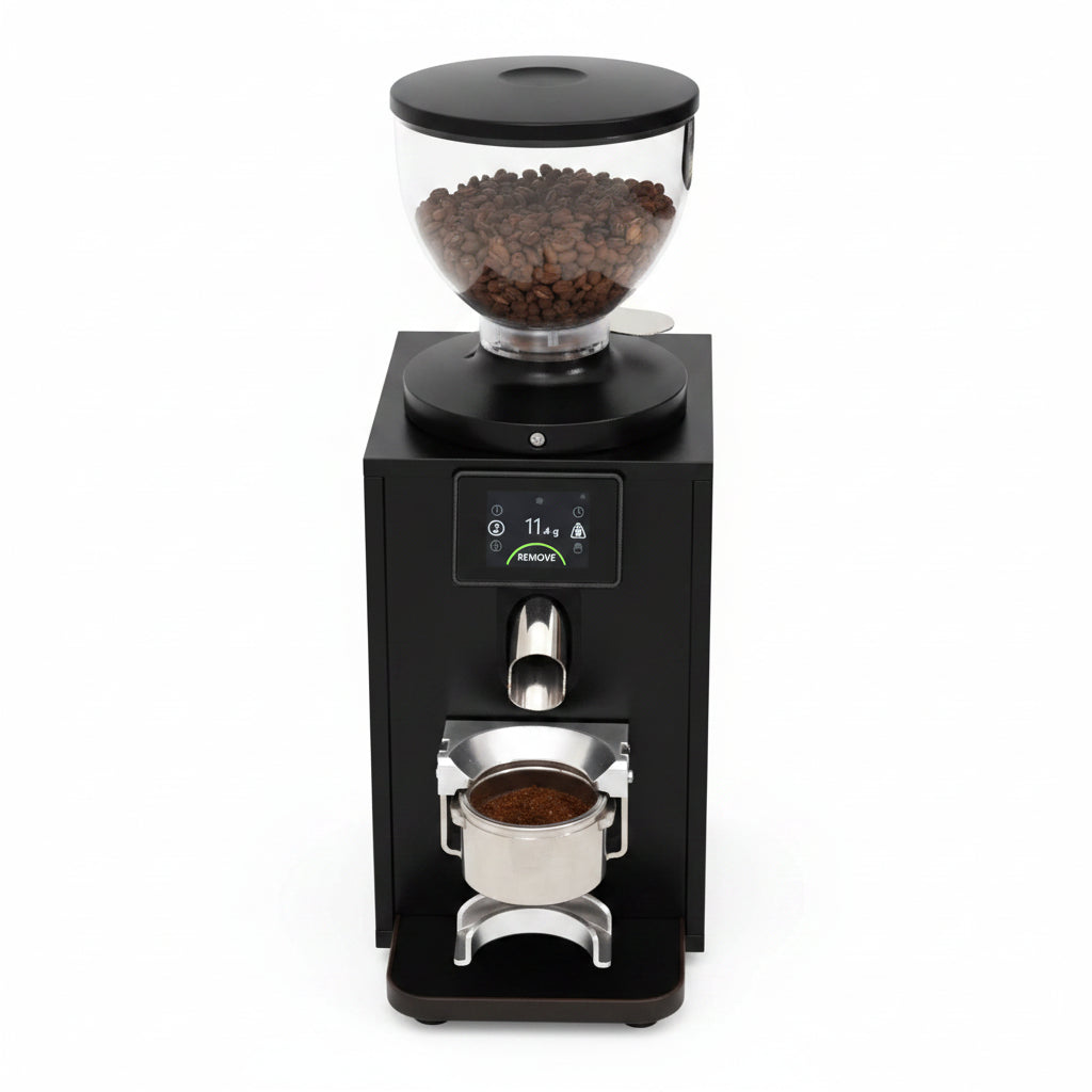 A close-up of a black coffee grinder with a clear bean hopper filled with coffee beans, a digital display screen, and a metal portafilter filled with ground coffee below.