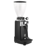 A black coffee grinder with a clear hopper, silver metal accents, and a black foot pedal, shown against a plain white background.